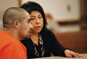 Spanish interpreter sitting next to defendant in court