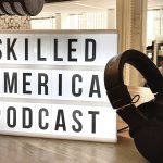 Living room in home with microphone, headphones and sign that says: Skilled America Podcast