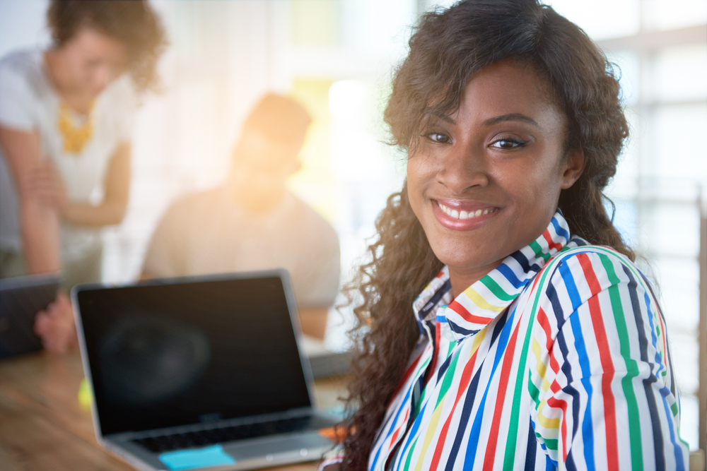 Image of a succesful casual business woman using laptop during meeting